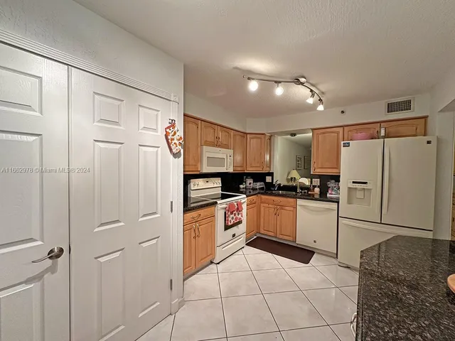 a kitchen with a refrigerator and white cabinets