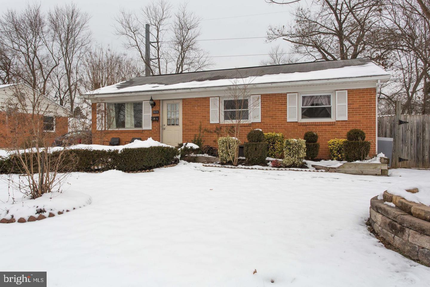 a front view of a house with a yard covered in snow