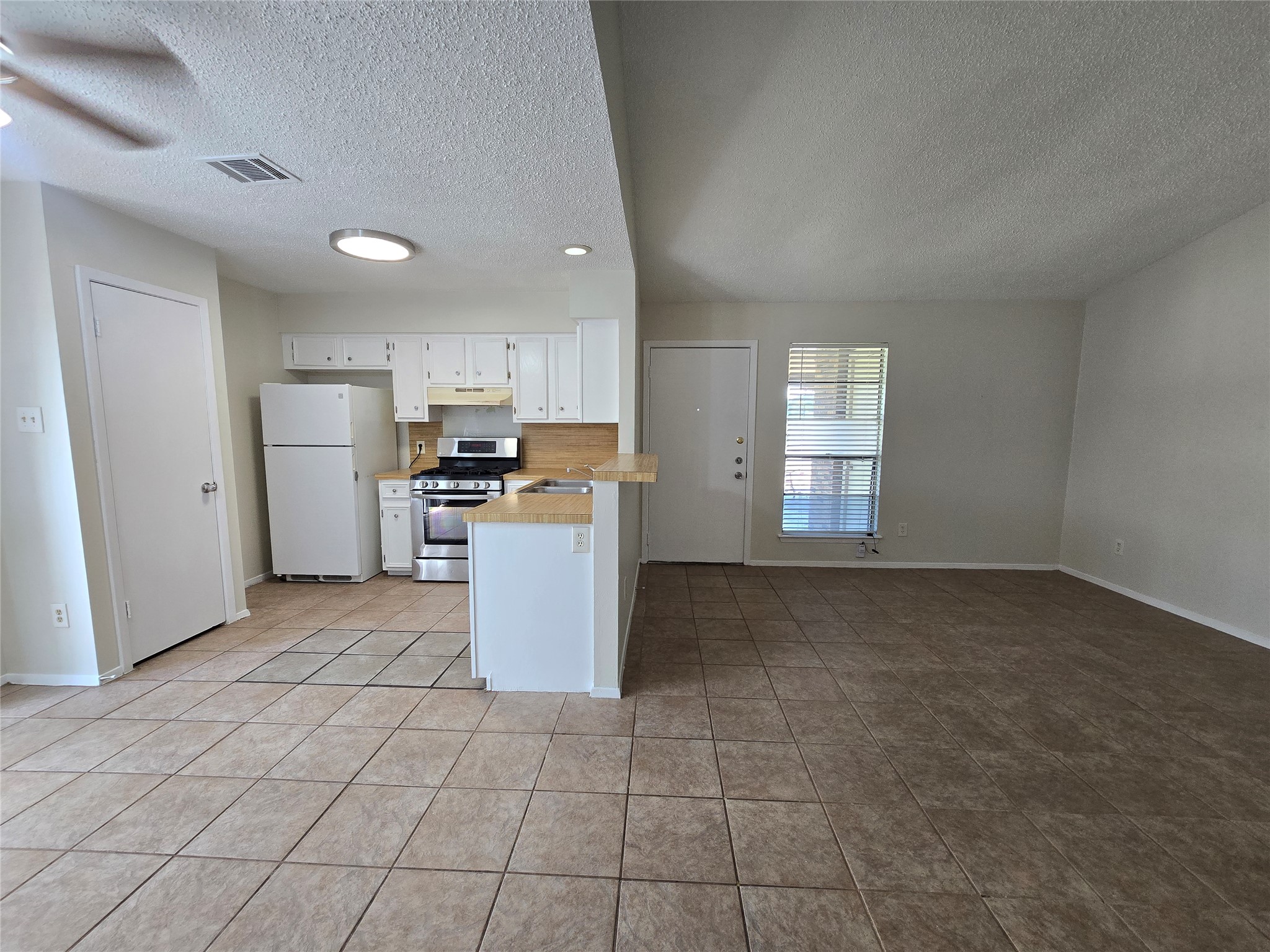 6206 Buffalo Pass, Unit A Austin, TX 78745 - Photo 7 of 24 Functional kitchen and living area, with tiled floors extending through the space.