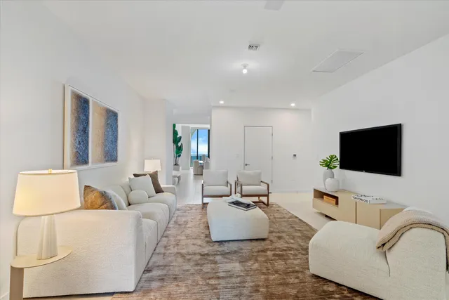 a living room with furniture a potted plant and a window