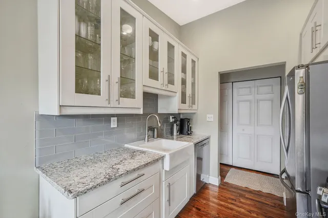 a kitchen with stainless steel appliances granite countertop a sink and a refrigerator