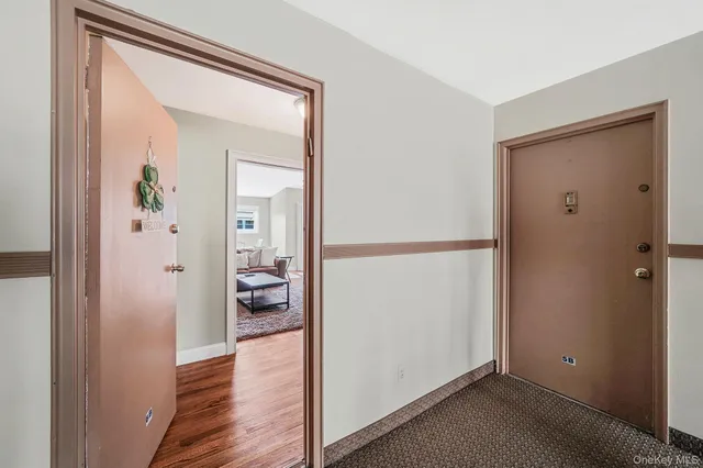 a view of a hallway with wooden floor and closet