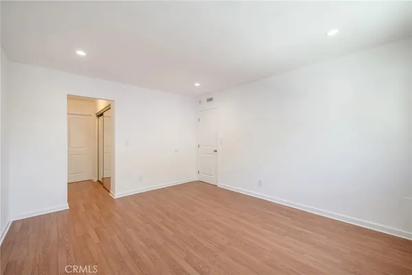an empty room with wooden floor and closet