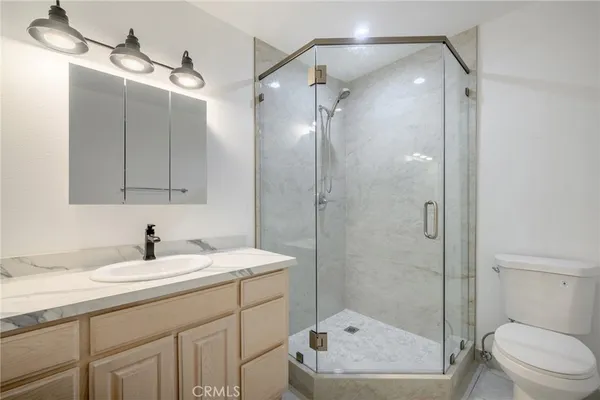 a bathroom with a sink a toilet and shower