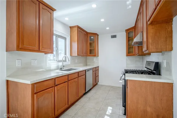 a kitchen with stainless steel appliances granite countertop wooden cabinets a sink and dishwasher