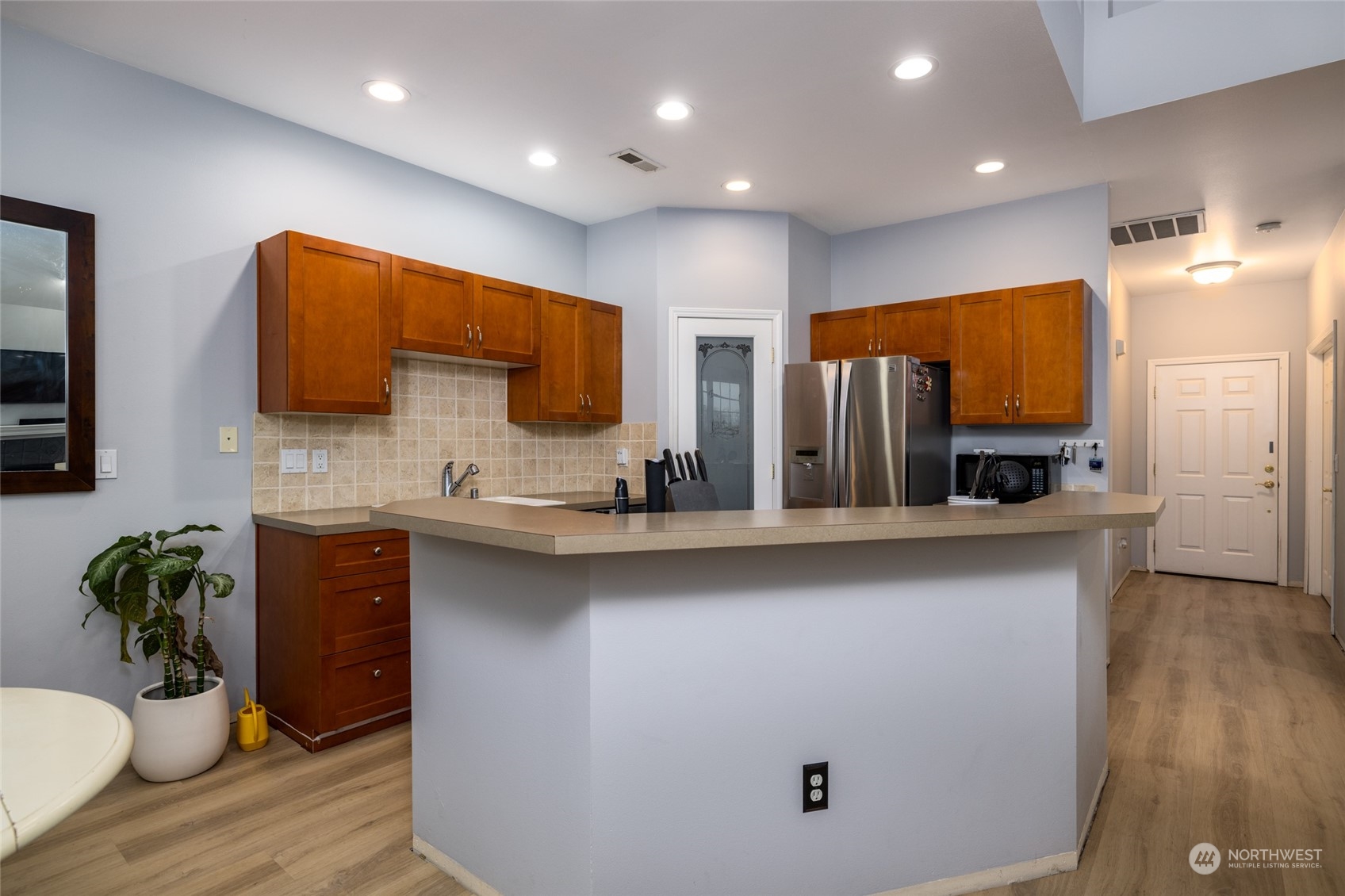 1505 Wildflower Way Sedro-Woolley, WA 98284 - Photo 14 of 24 a kitchen with stainless steel appliances a sink dishwasher a refrigerator and a dining table with wooden floor