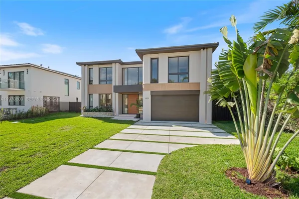 a front view of a house with a garden and yard