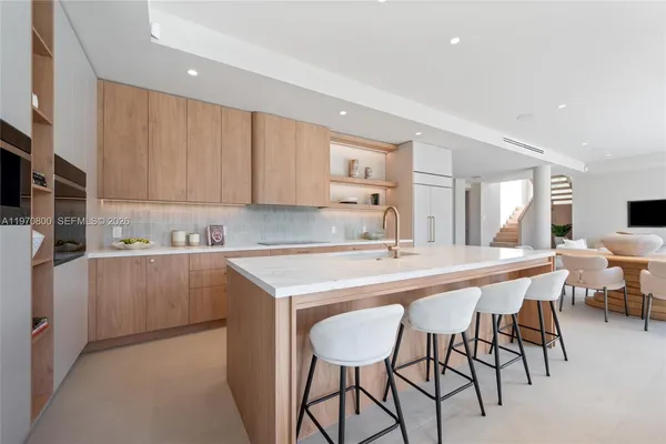 a kitchen with a sink and chairs