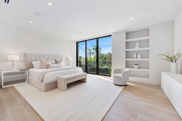 a spacious bedroom with a large bed couch and a large window