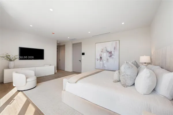 a bedroom with a bed and a flat screen tv