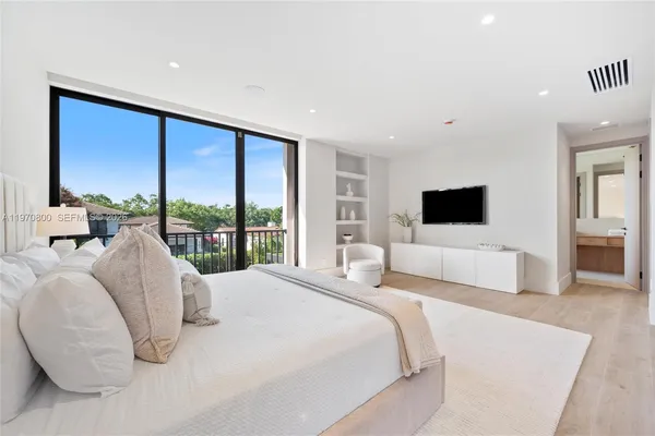 a bedroom with a large bed and a flat screen tv