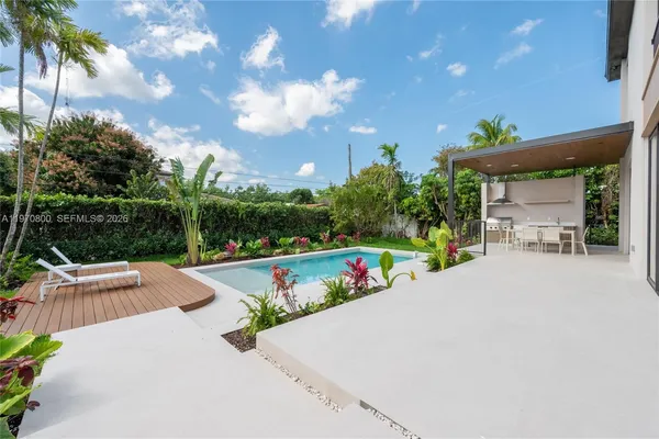 a view of a patio with a table and chairs under an umbrella