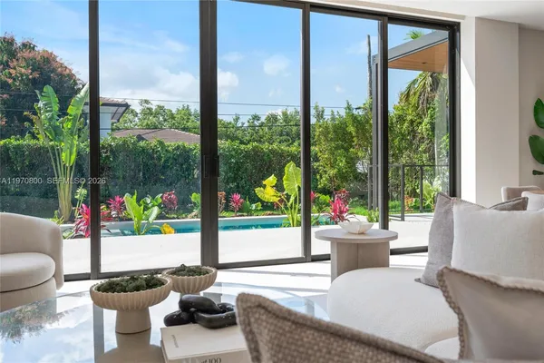 a living room with patio furniture and a potted plant