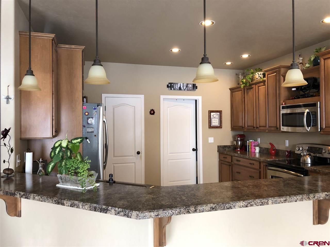 3016 Outlook Road Montrose, CO 81401 - Photo 12 of 30 looking into the kitchen from the dining area. 2 white doors pantry on the left laundry/garage