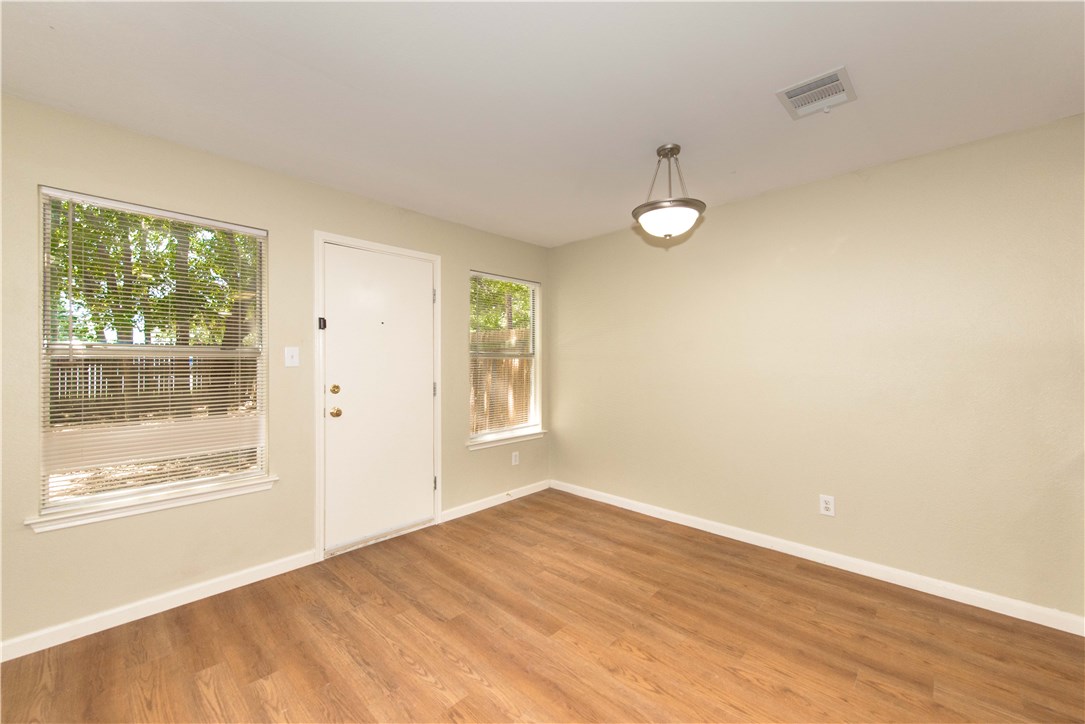 9710 Sugar Hill Drive, Unit A Austin, TX 78748 - Photo 13 of 40 an empty room with wooden floor and windows