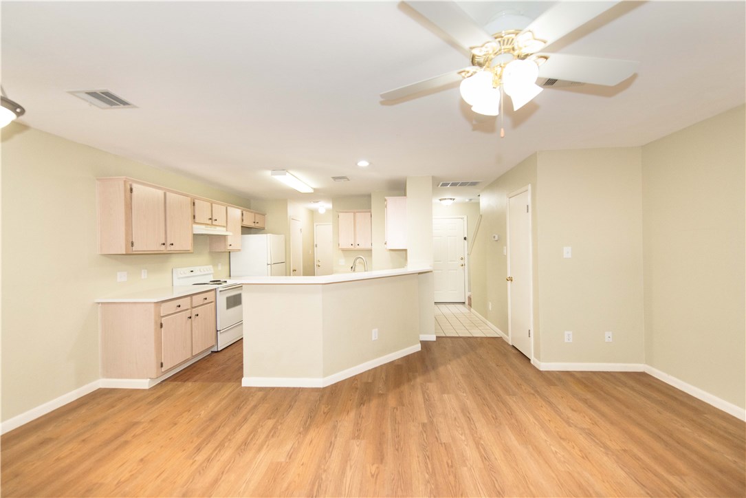 9710 Sugar Hill Drive, Unit A Austin, TX 78748 - Photo 2 of 40 a large kitchen with cabinets wooden floor and a refrigerator