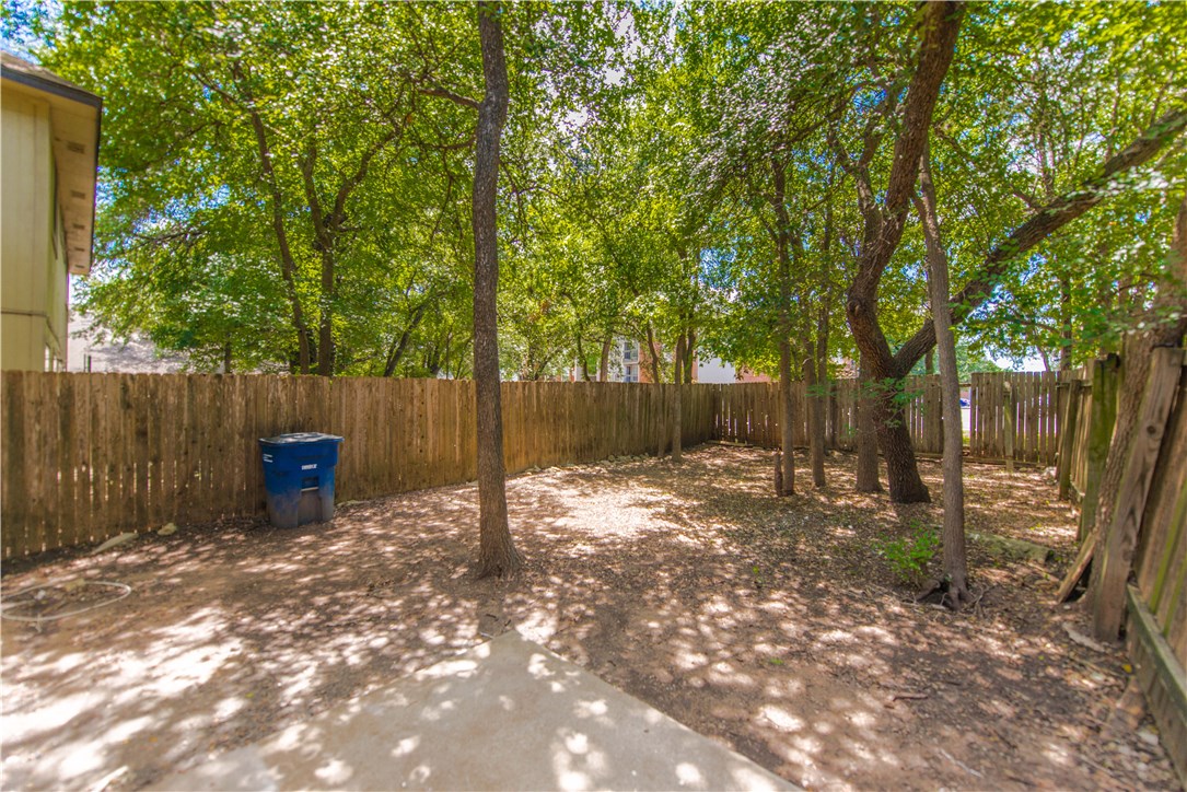 9710 Sugar Hill Drive, Unit A Austin, TX 78748 - Photo 35 of 40 a backyard of a house with table and chairs a fire pit and a large tree