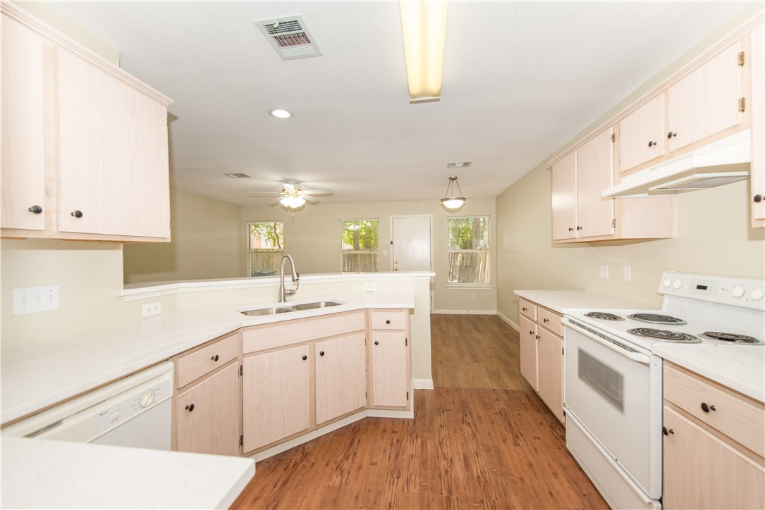 9710 Sugar Hill Drive, Unit A Austin, TX 78748 - Photo 8 of 40 a kitchen with granite countertop white cabinets and white appliances