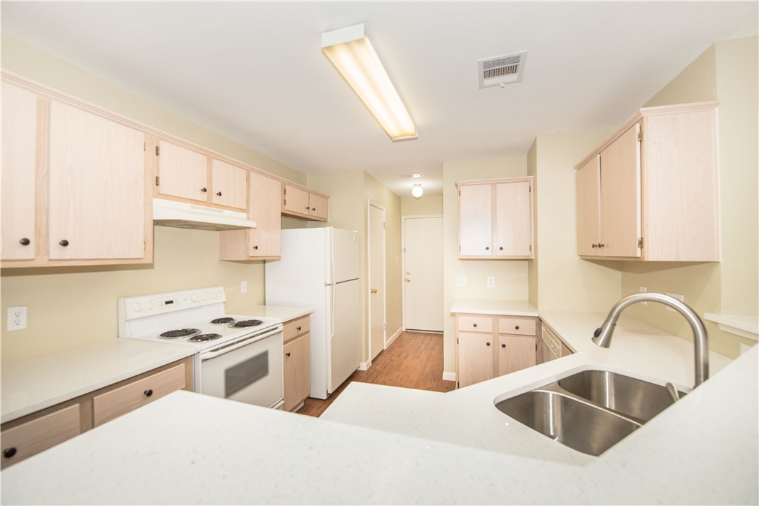 9710 Sugar Hill Drive, Unit A Austin, TX 78748 - Photo 9 of 40 a kitchen with white cabinets a sink and white appliances