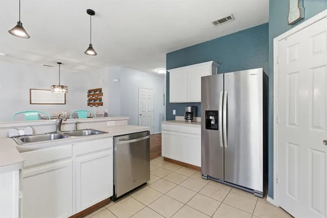 a kitchen with stainless steel appliances a refrigerator sink and microwave
