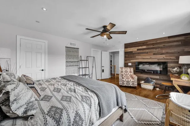 a bedroom with a bed a dresser and a chandelier