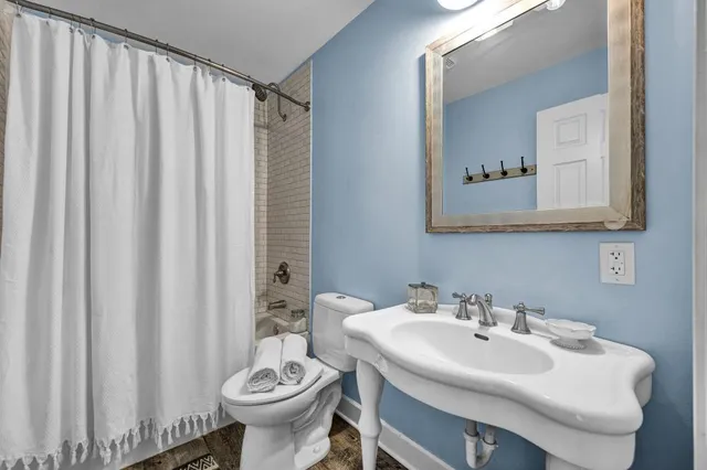 a bathroom with a sink toilet and a mirror