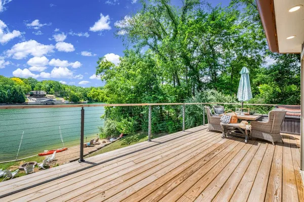 a view of a balcony with wooden floor and lake view
