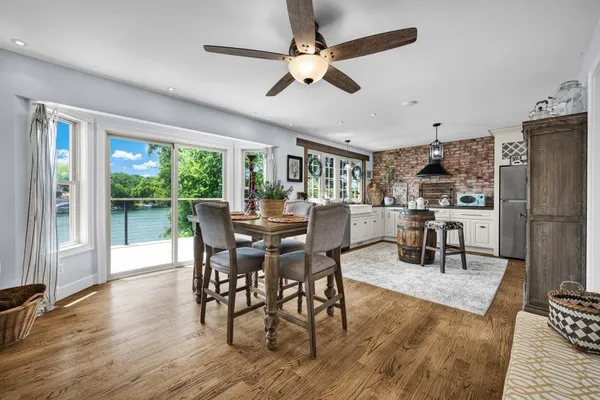 a dining room with furniture a floor to ceiling window and wooden floor