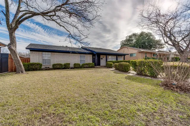 a front view of a house with a yard and potted plants