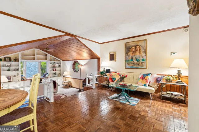 a living room with lots of furniture and a painting on the wall