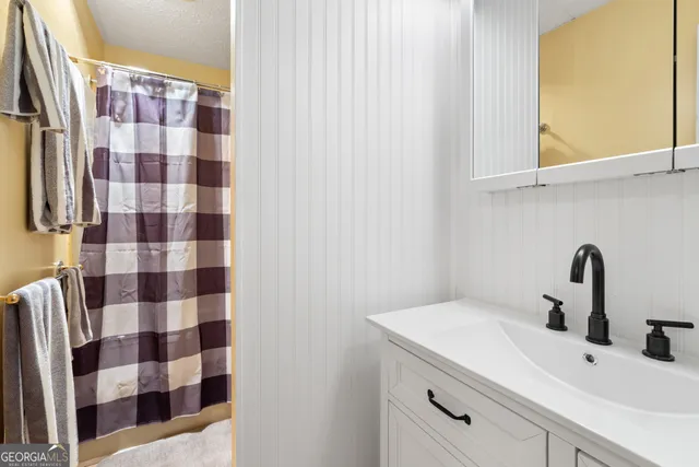 a bathroom with a sink a mirror and shower