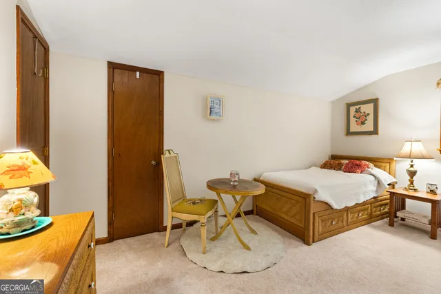 a spacious bedroom with a bed and chair