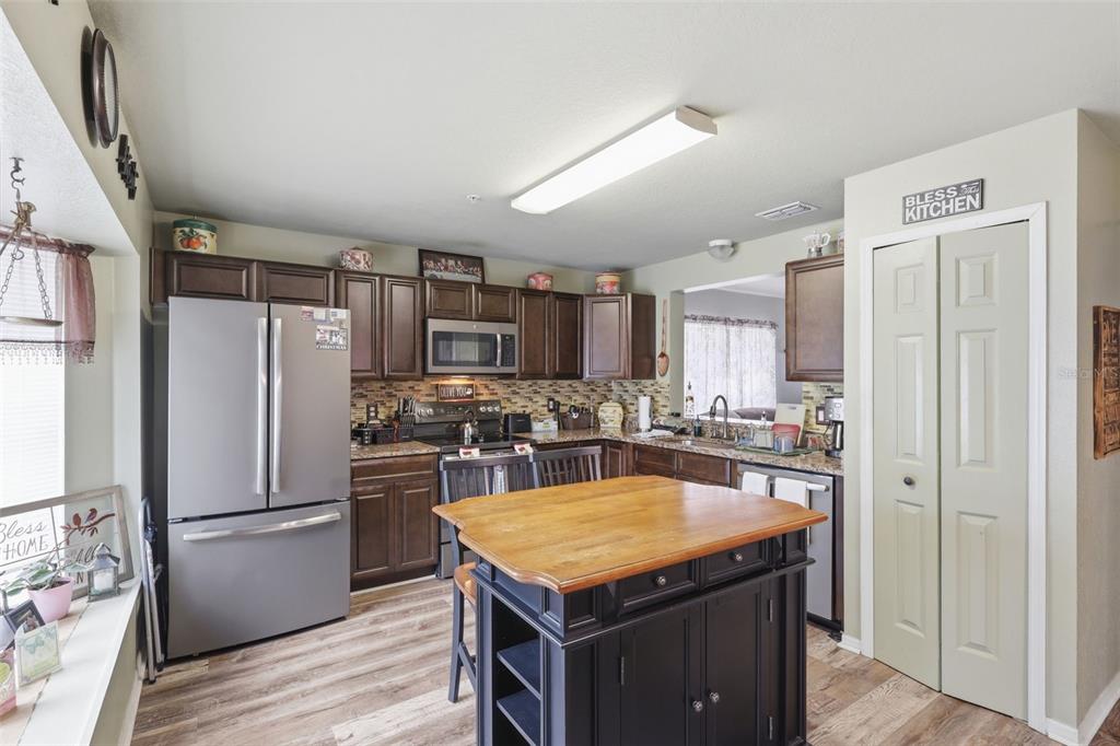 3440 Allston Lane Winter Park, FL 32792 - Photo 7 of 37 a kitchen with a refrigerator a kitchen island white cabinetry and wooden floor