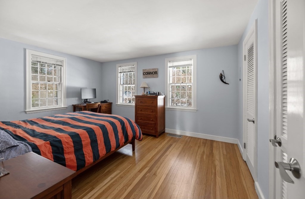 30 3 Ponds Road Wayland, MA 01778 - Photo 13 of 28 a bedroom with a bed and wooden floor