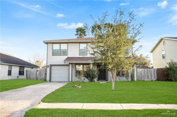 a front view of a house with a garden and yard