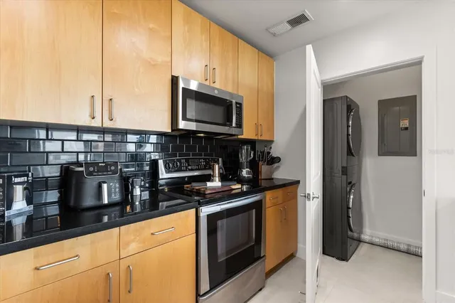 a kitchen with stainless steel appliances granite countertop a stove a sink and a microwave