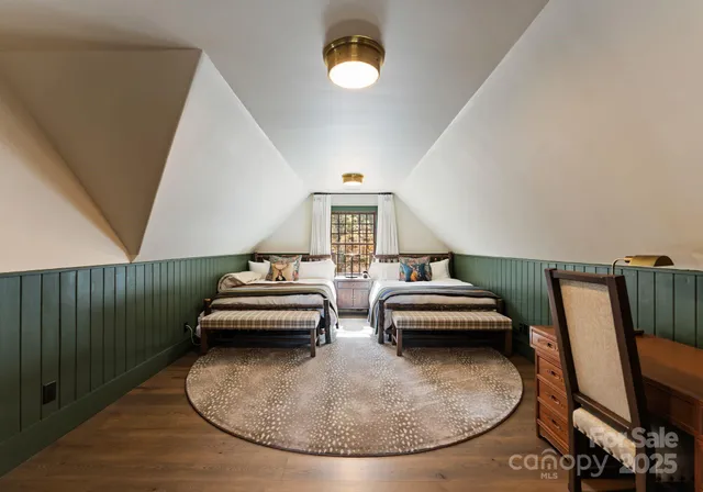 a view of a bedroom with furniture and wooden floor