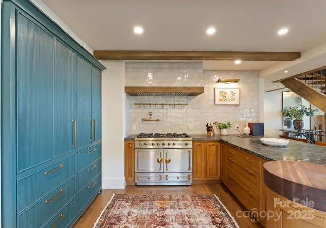 a kitchen with stainless steel appliances granite countertop a sink stove and cabinets