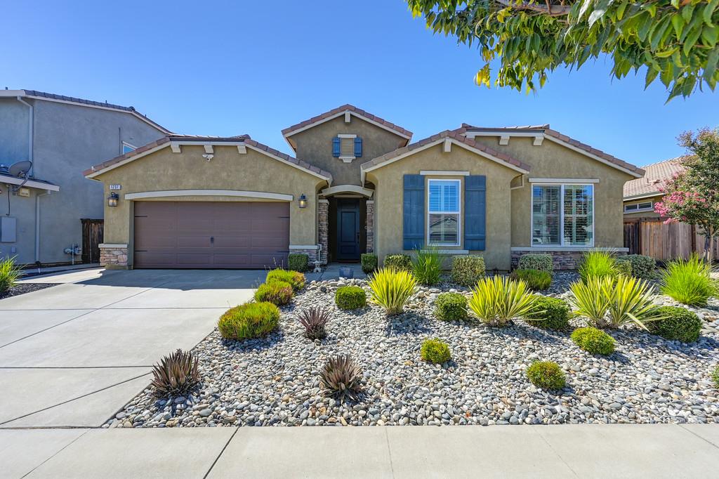 a front view of a house with a garden