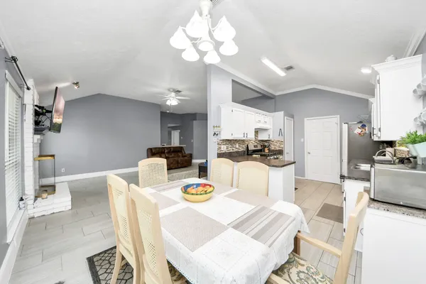a kitchen with stainless steel appliances kitchen island granite countertop a refrigerator a stove a microwave oven with a dining table and chairs