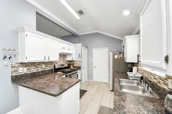 a kitchen with stainless steel appliances granite countertop a sink stove and refrigerator