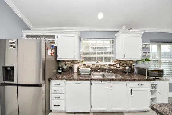a kitchen with granite countertop a sink cabinets and window