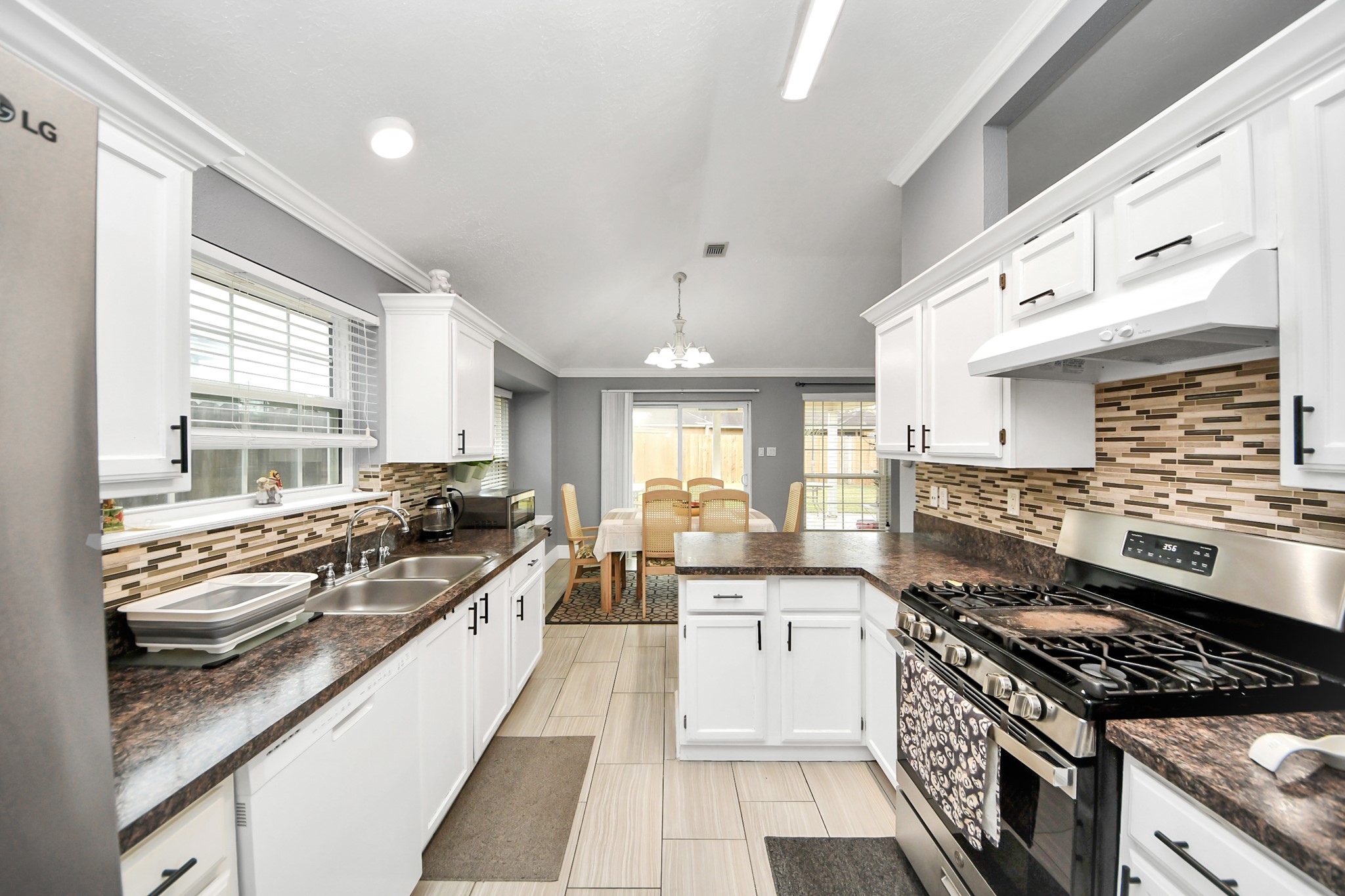 17702 Poppy Trails Lane Houston, TX 77084 - Photo 18 of 37 a large white kitchen with stainless steel appliances granite countertop a stove and a sink