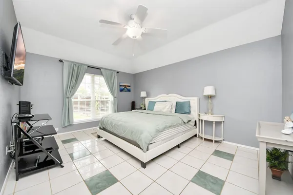 a bedroom with a bed window and a flat screen tv
