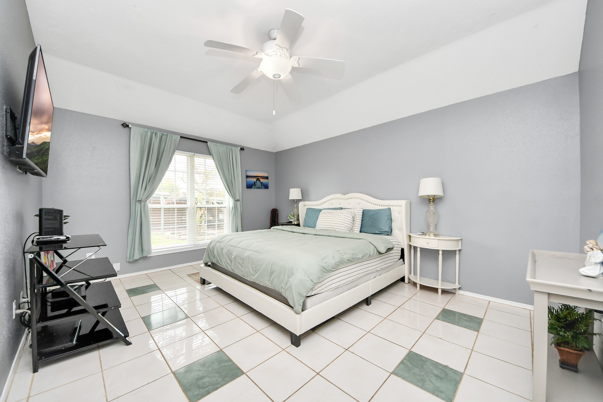 17702 Poppy Trails Lane Houston, TX 77084 - Photo 19 of 37 a bedroom with a bed window and a flat screen tv