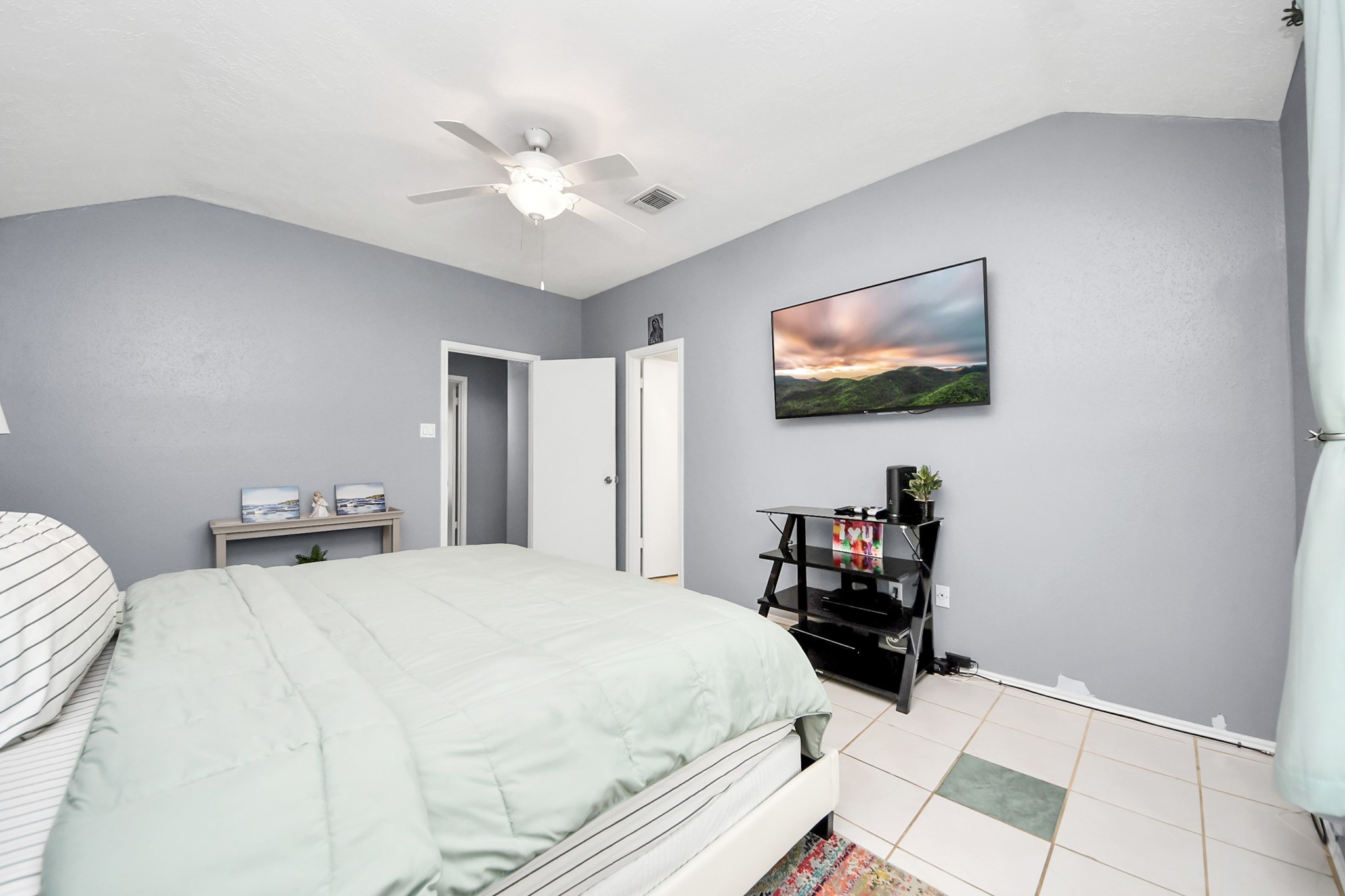 17702 Poppy Trails Lane Houston, TX 77084 - Photo 21 of 37 a bedroom with a bed and a chandelier