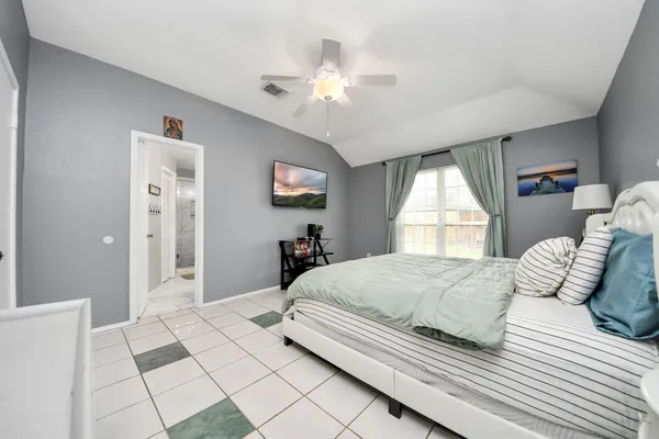 a bedroom with a large bed and a chandelier