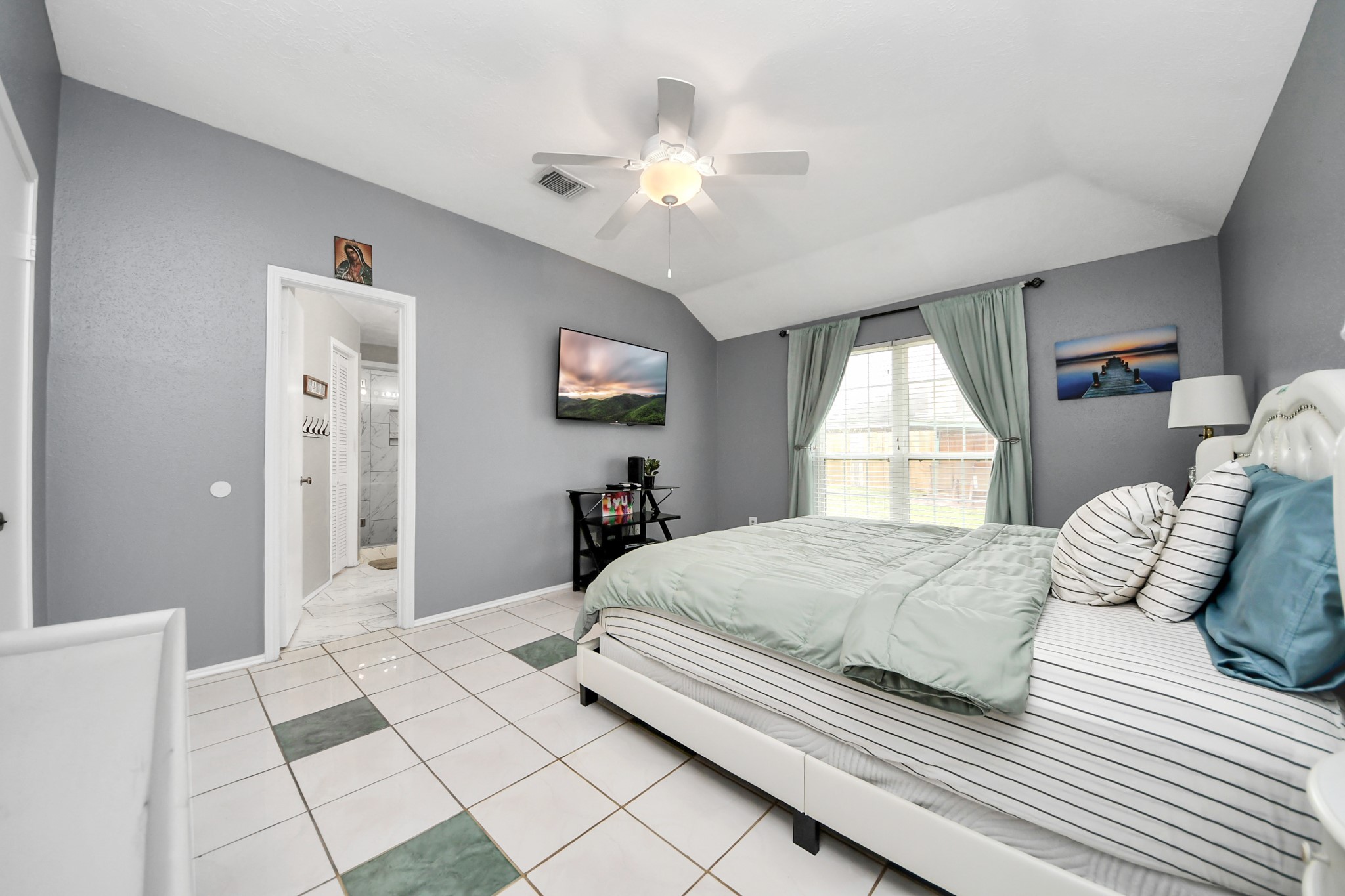 17702 Poppy Trails Lane Houston, TX 77084 - Photo 22 of 37 a bedroom with a large bed and a chandelier
