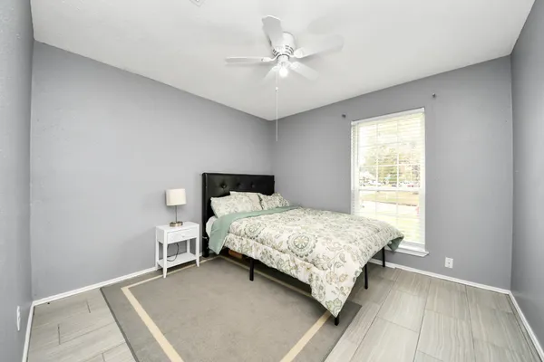 a bedroom with a bed and a ceiling fan