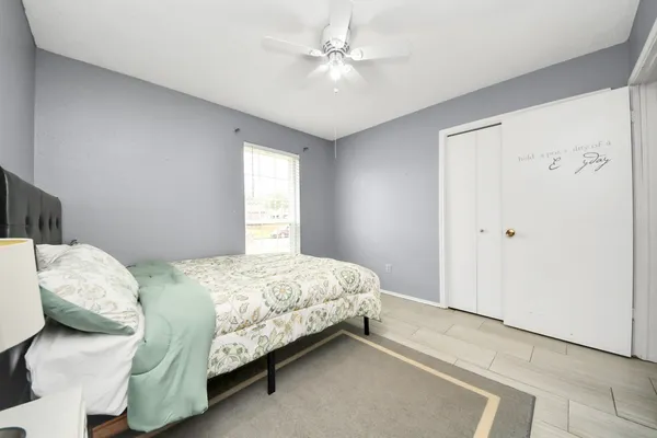 a bedroom with a bed and a chandelier fan